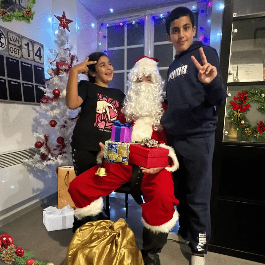 deux enfants avec un père noël à domicile