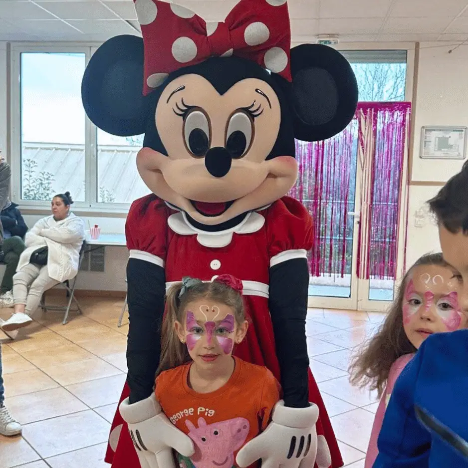 mascotte minnie mouse avec une petite fille et d'autres enfants